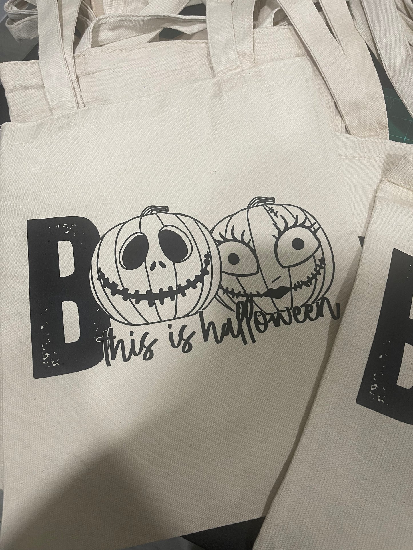 Eco-friendly “Boo This is Halloween” tote bag with spooky text and fall-themed design, perfect for Halloween accessories and trick-or-treating.