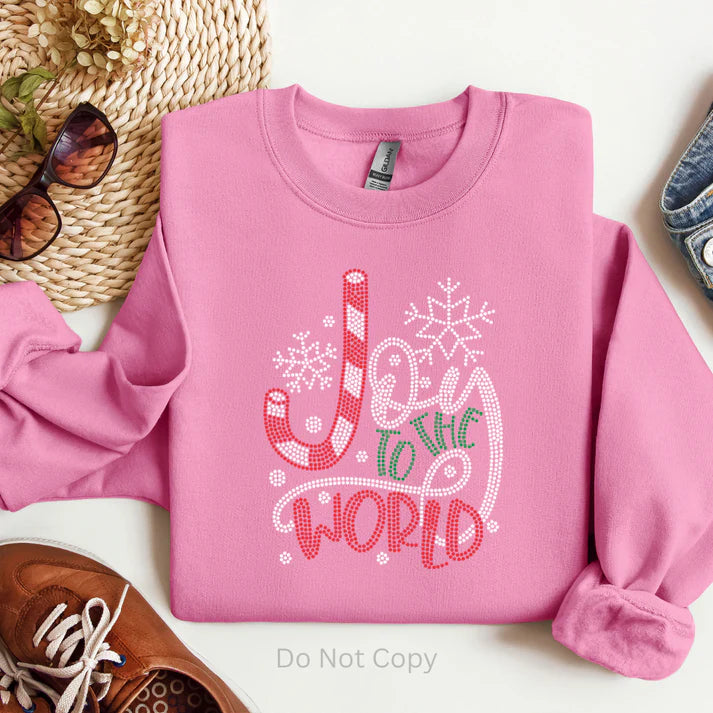 Joy to the World rhinestone Christmas sweatshirt featuring a sparkling holiday design on a soft pink sweatshirt, perfect for faith-based winter outfits and festive wear.