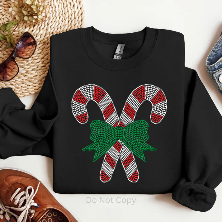 Candy cane rhinestone sweatshirt featuring sparkling red and white candy canes with a green bow on a black Christmas sweatshirt by LDC Designz.