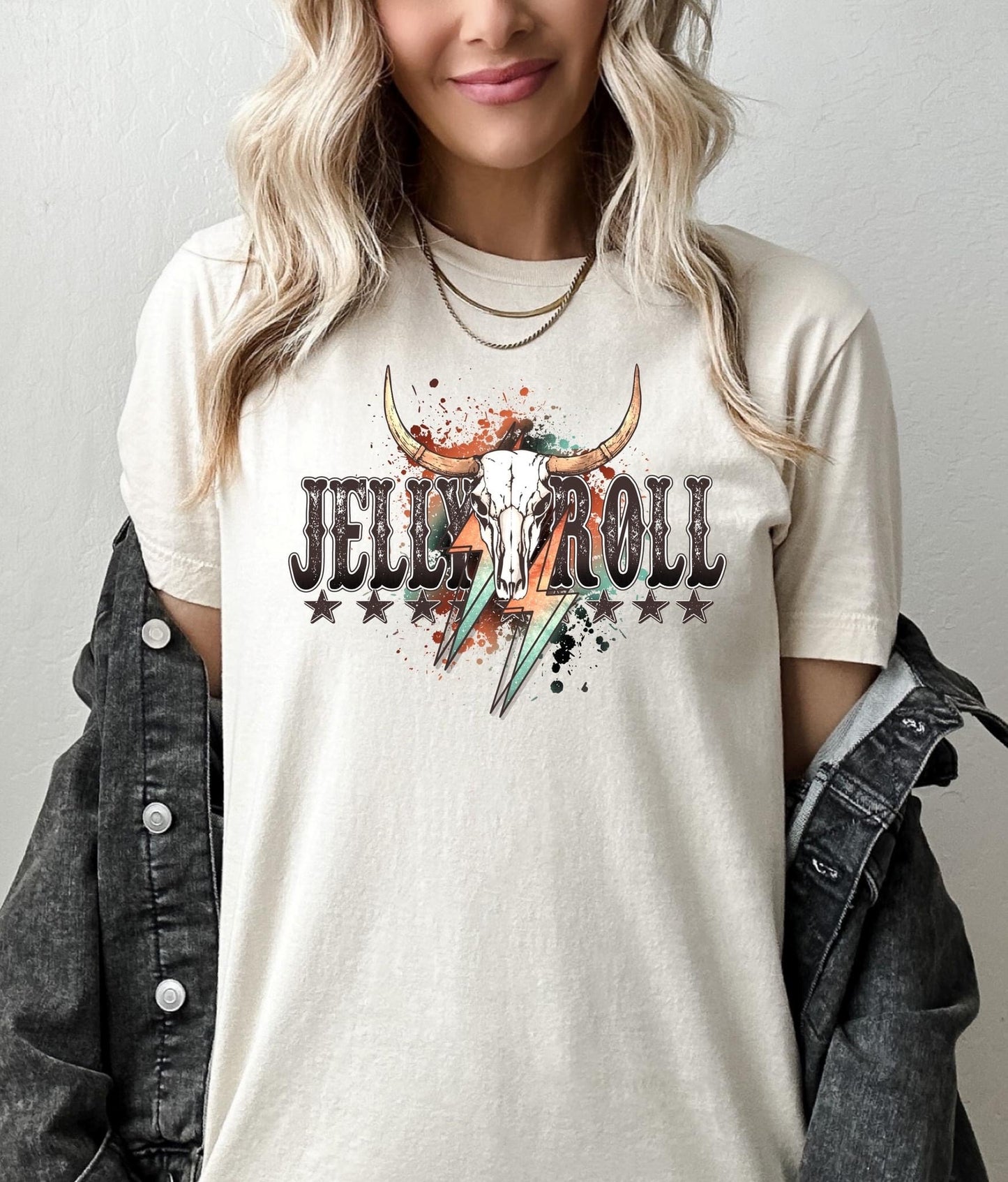 A person wearing a beige t-shirt with 'Jelly Roll' text and a graphic of a bull's skull and stars printed on the front.