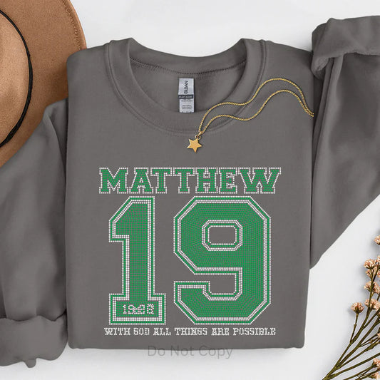 Matthew 19 rhinestone sweatshirt featuring green sparkling rhinestone design with “With God All Things Are Possible” Bible verse on a gray Christian faith sweatshirt by LDC Designz.