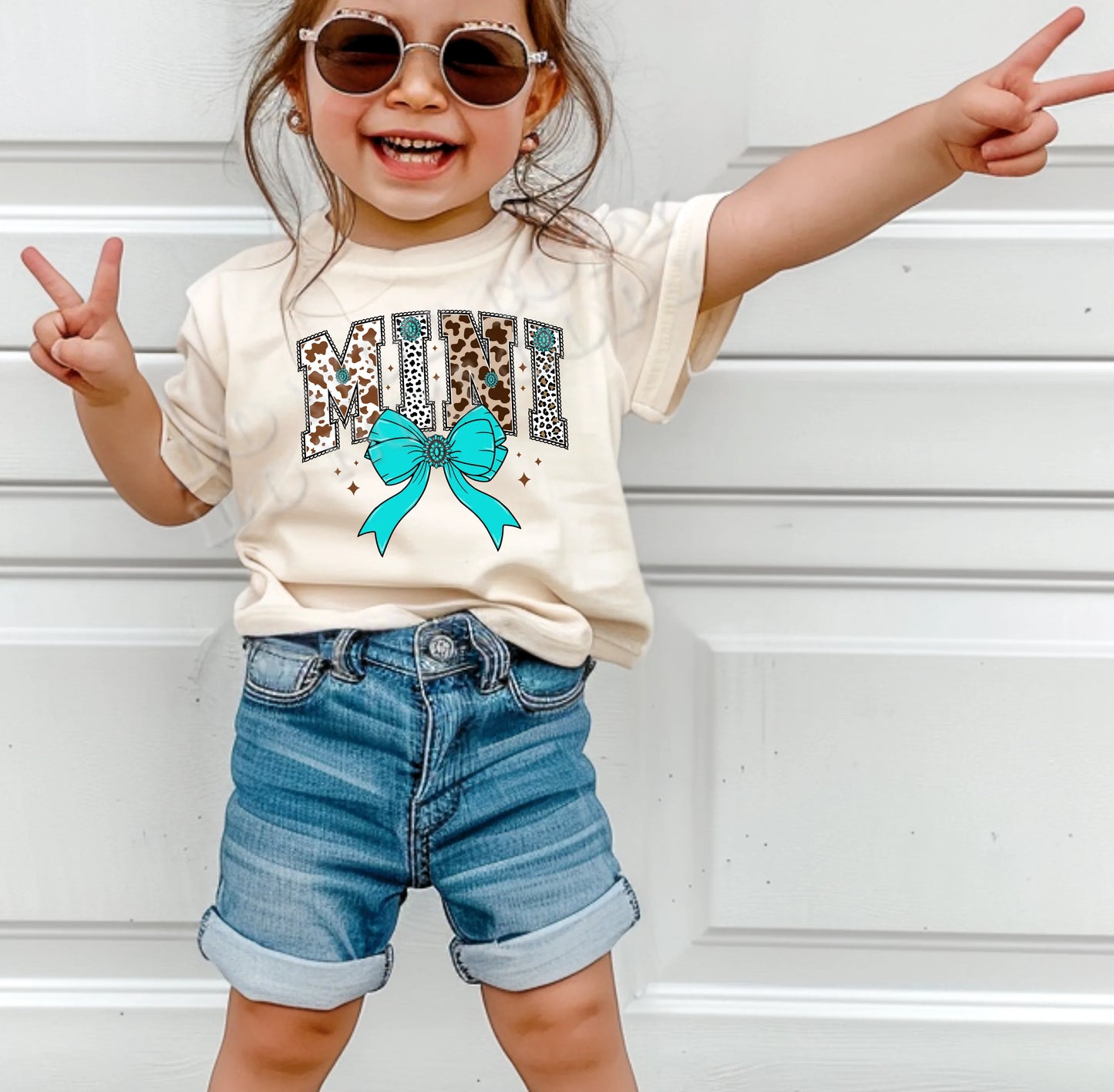 Mini Cow Print with Turquoise Bow T-Shirt for toddlers and youth – western cow print kids’ tee with turquoise bow from LDC Designz.