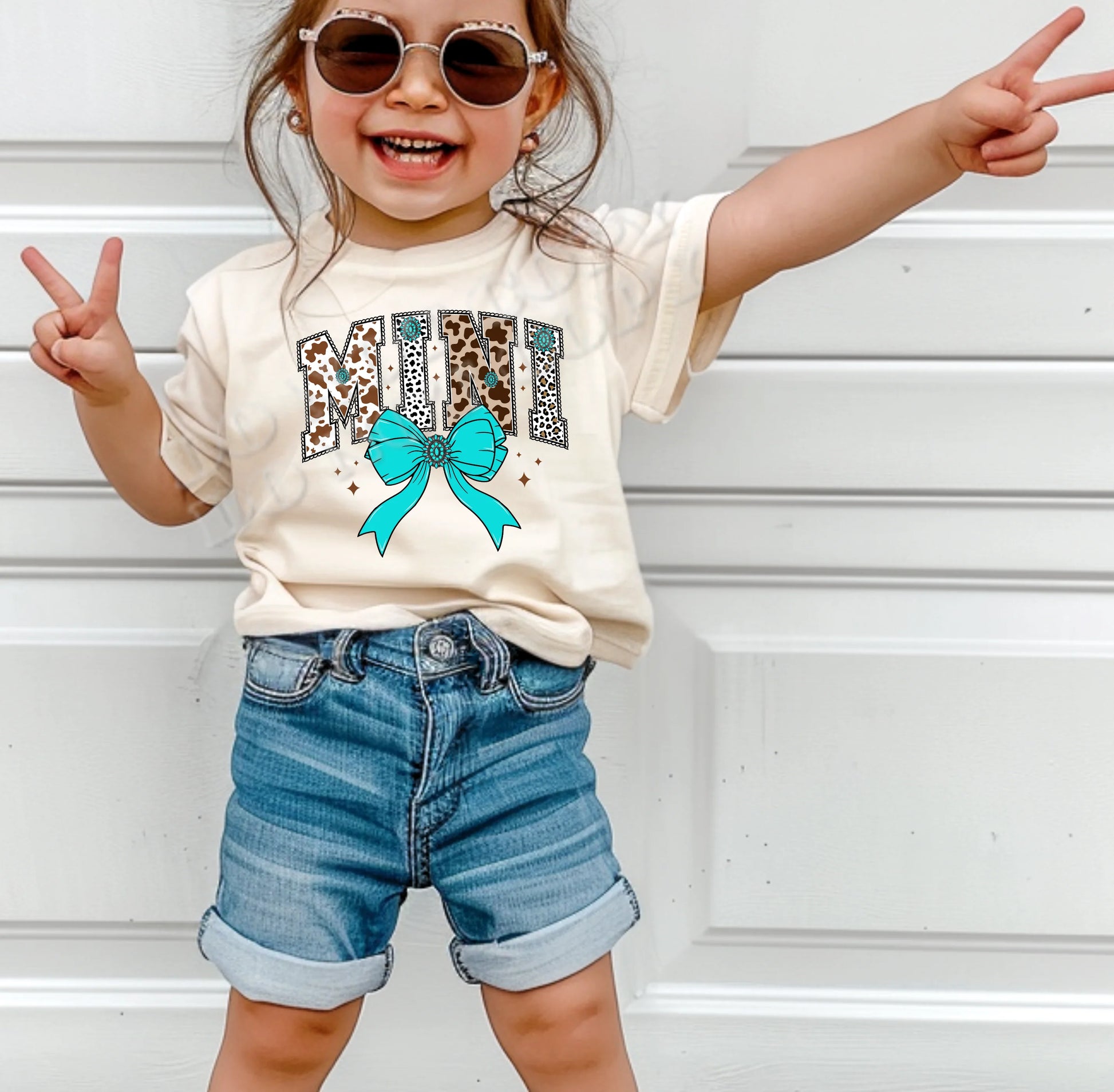 Mini Cow Print with Turquoise Bow T-Shirt for toddlers and youth – western cow print kids’ tee with turquoise bow from LDC Designz.